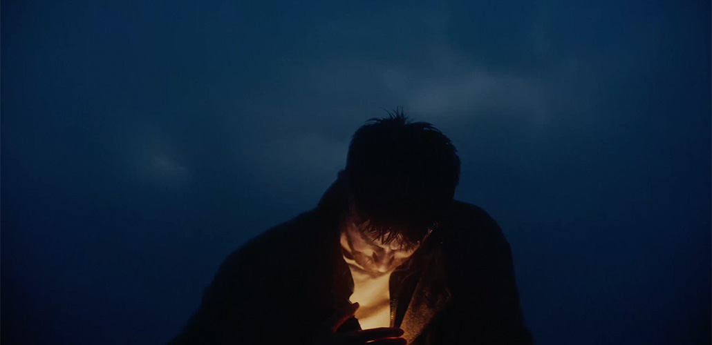 Man protecting candle flame in a storm